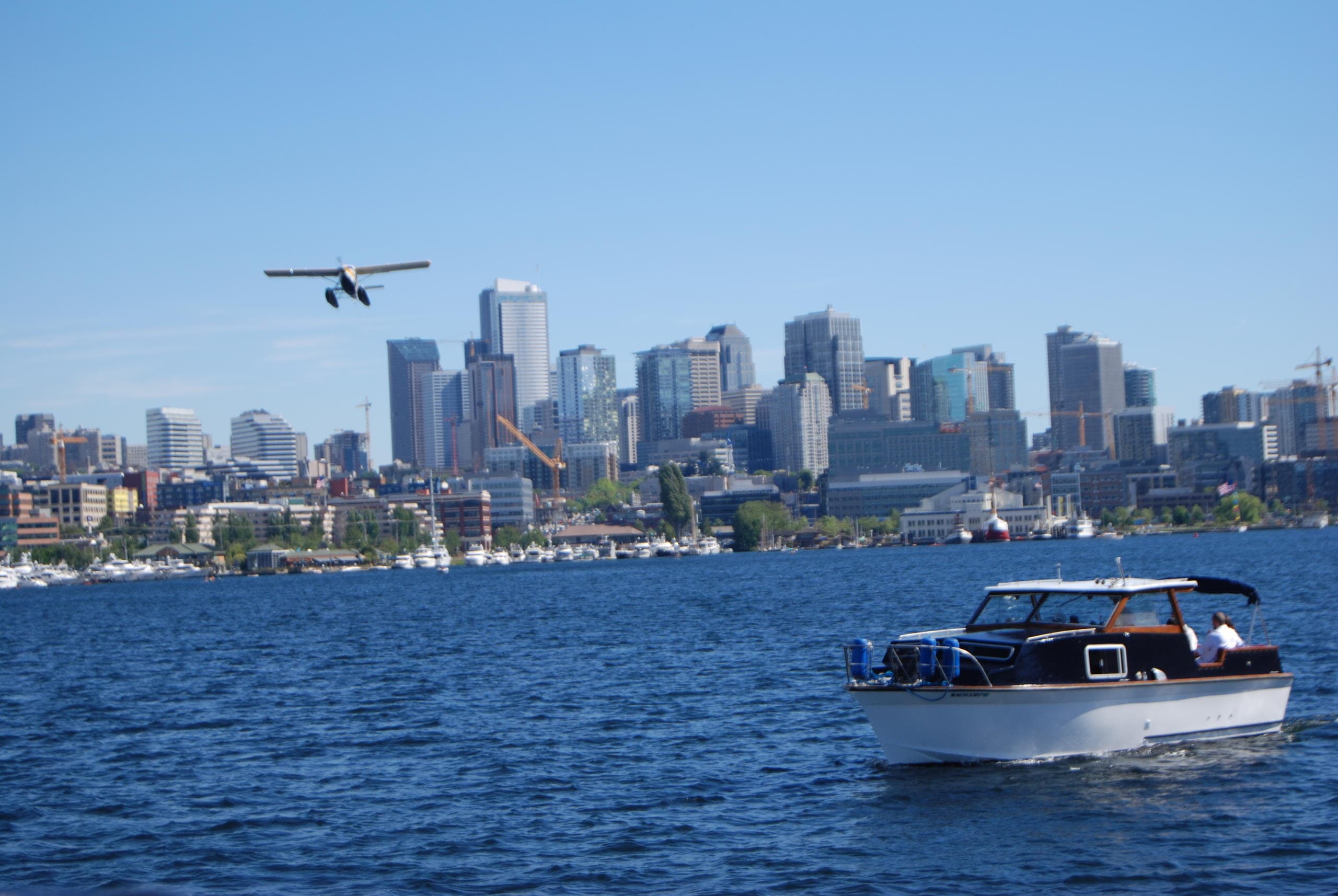 City skyline cruise with boat crossing harbor under blue sky