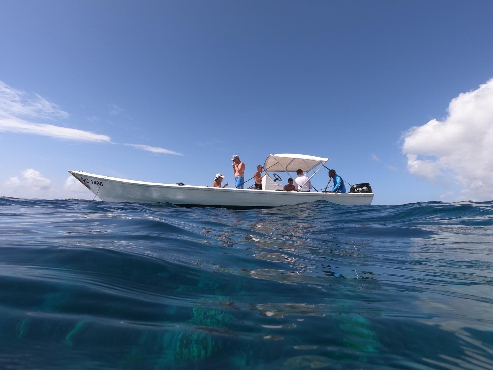 Tour boat on calm Caribbean sea with crew and open sky