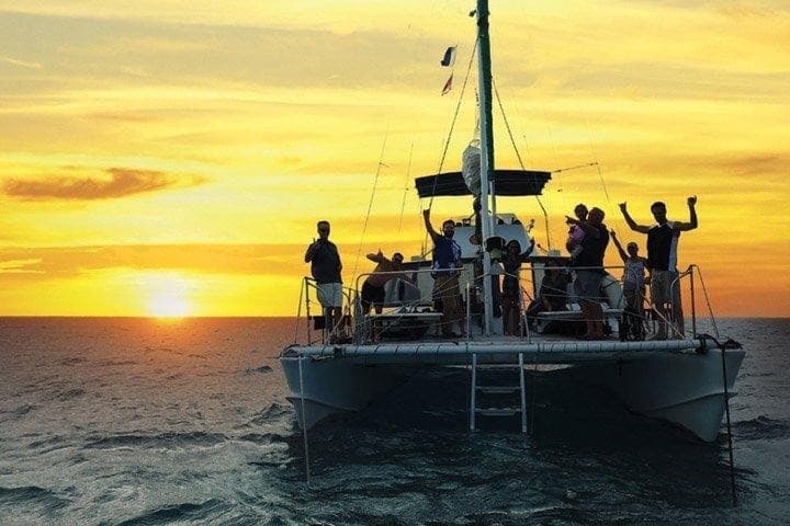 Sunset catamaran cruise with passengers on the open ocean