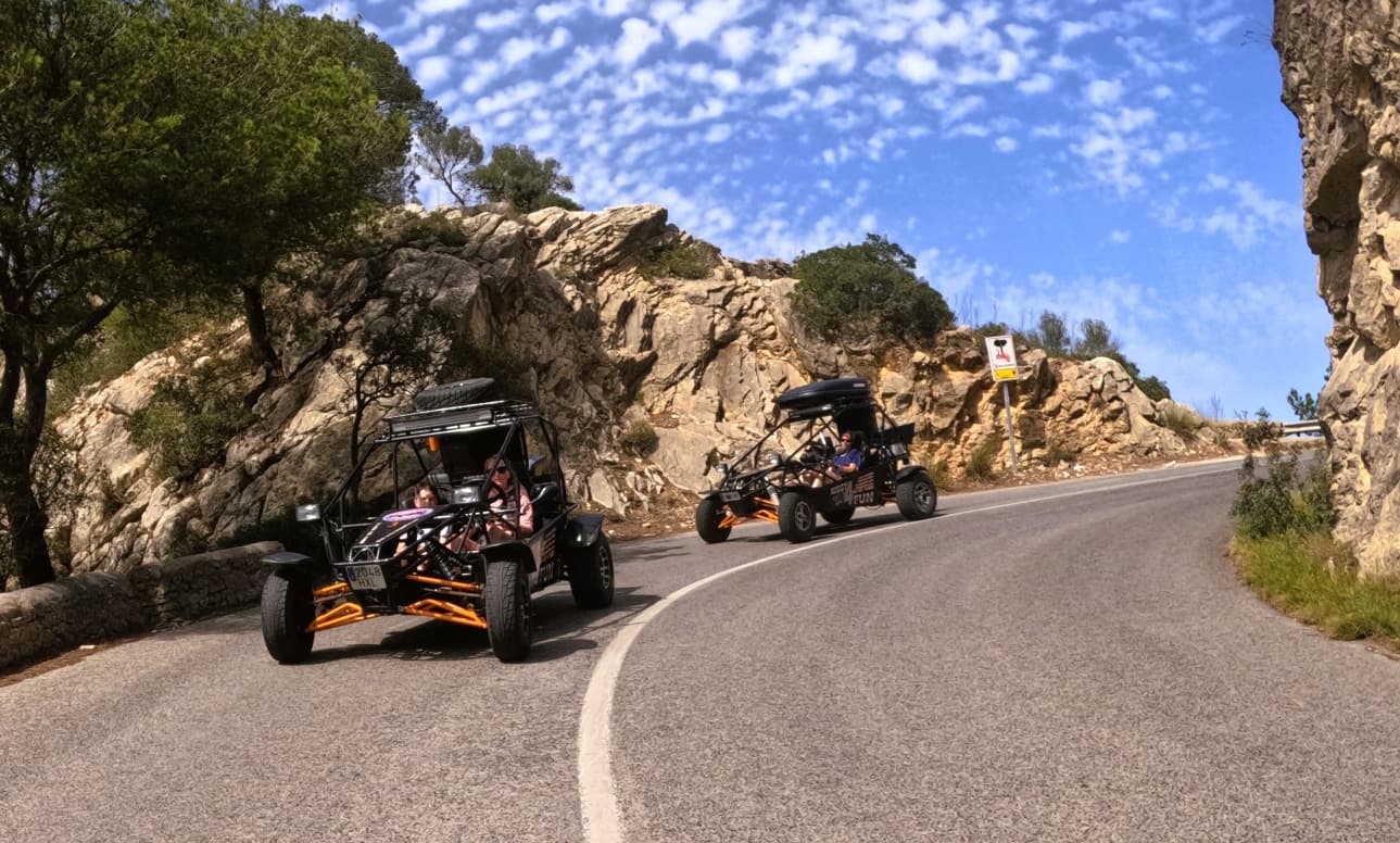 Dune buggies driving a winding coastal cliff road