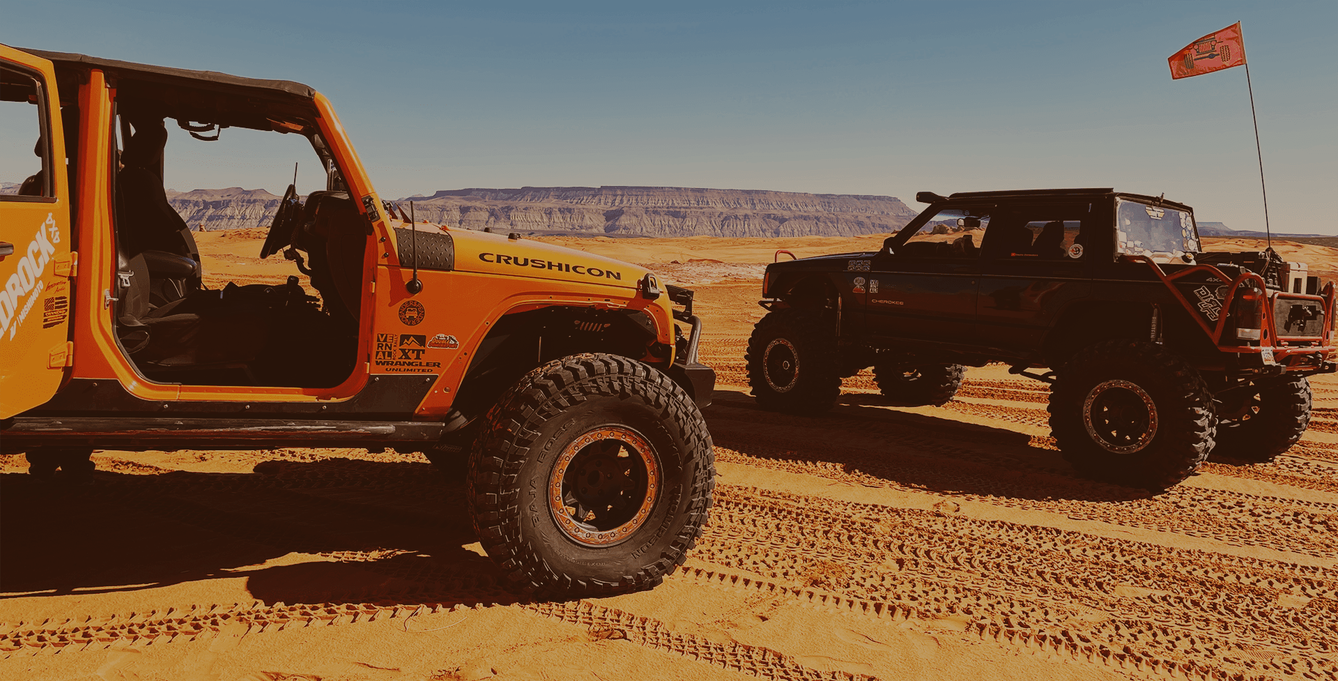 Open-top Jeeps traversing sandy beach-like desert tracks