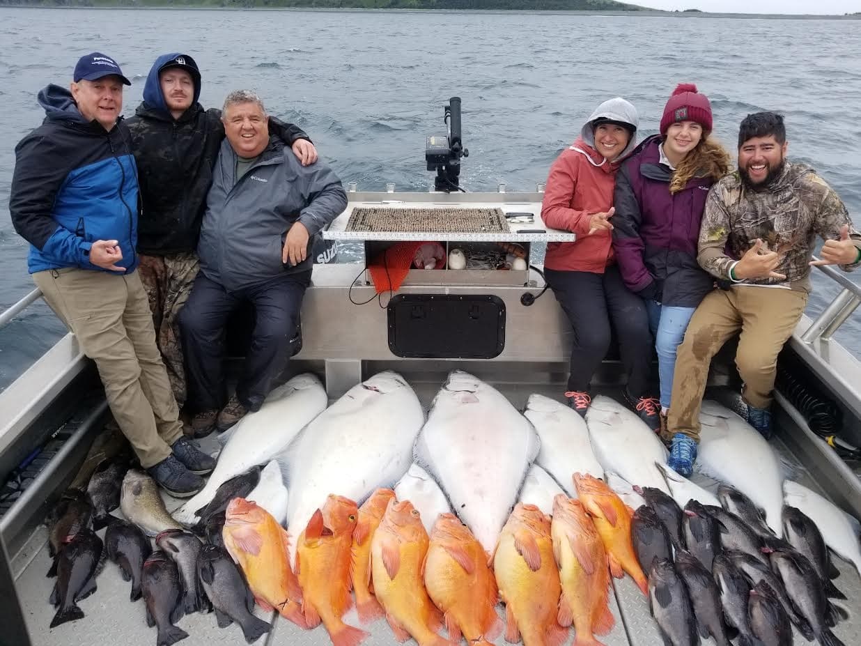 Group of anglers with mixed catch on deck of charter boat