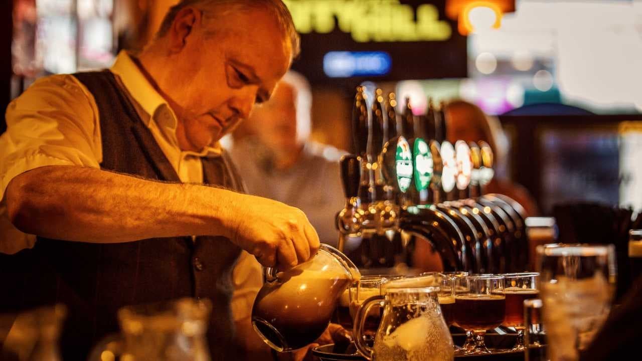 Pub bartender pouring draft beer during Westport evening walk