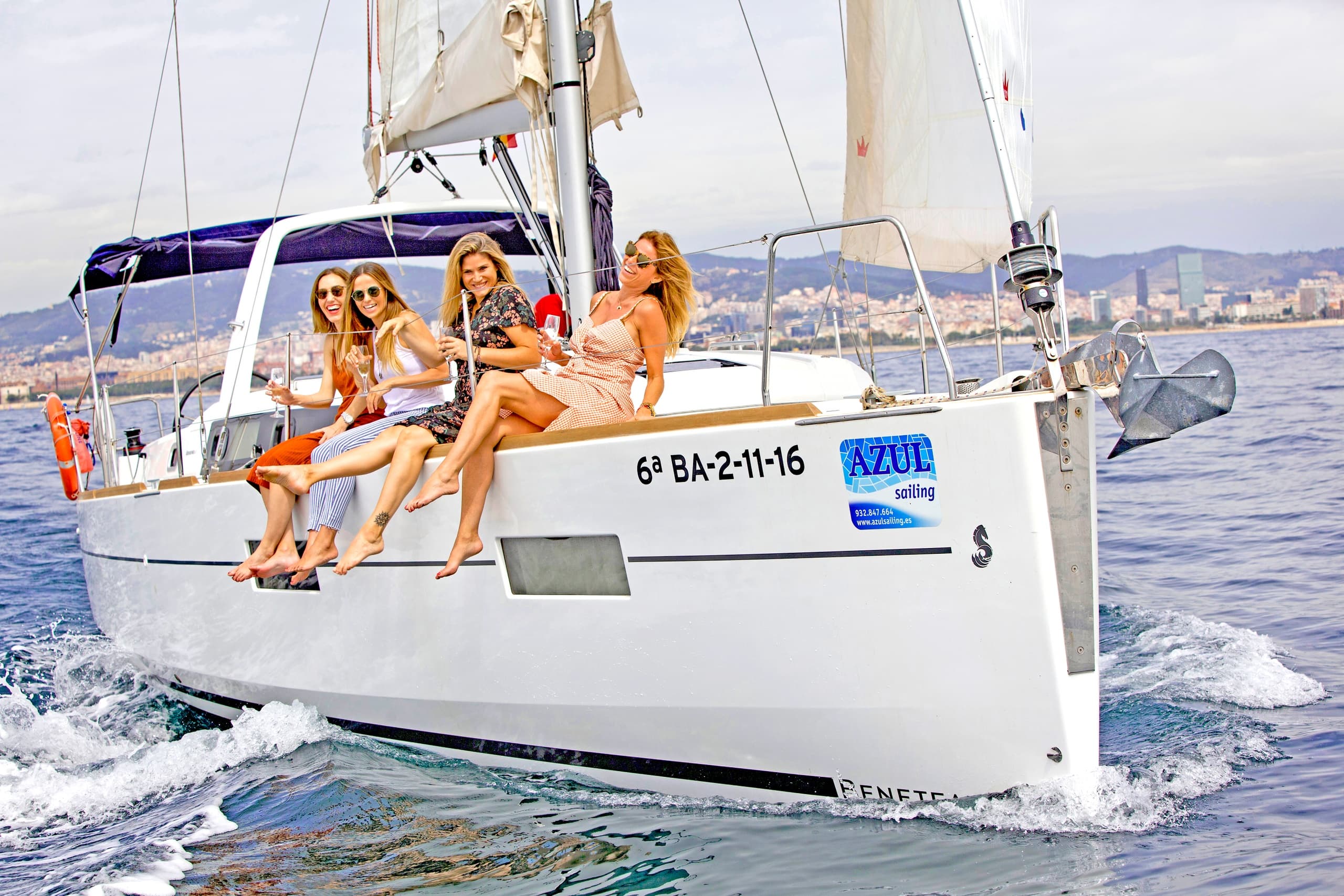 Group of friends on sailboat bow enjoying Mediterranean cruise