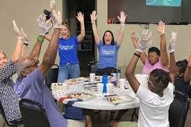 Participants raising hands during indoor chocolate-making class