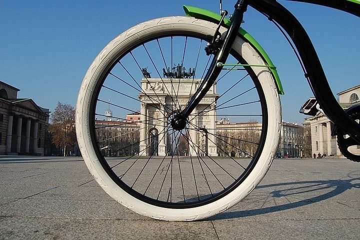 Close-up bicycle wheel with urban monument plaza backdrop