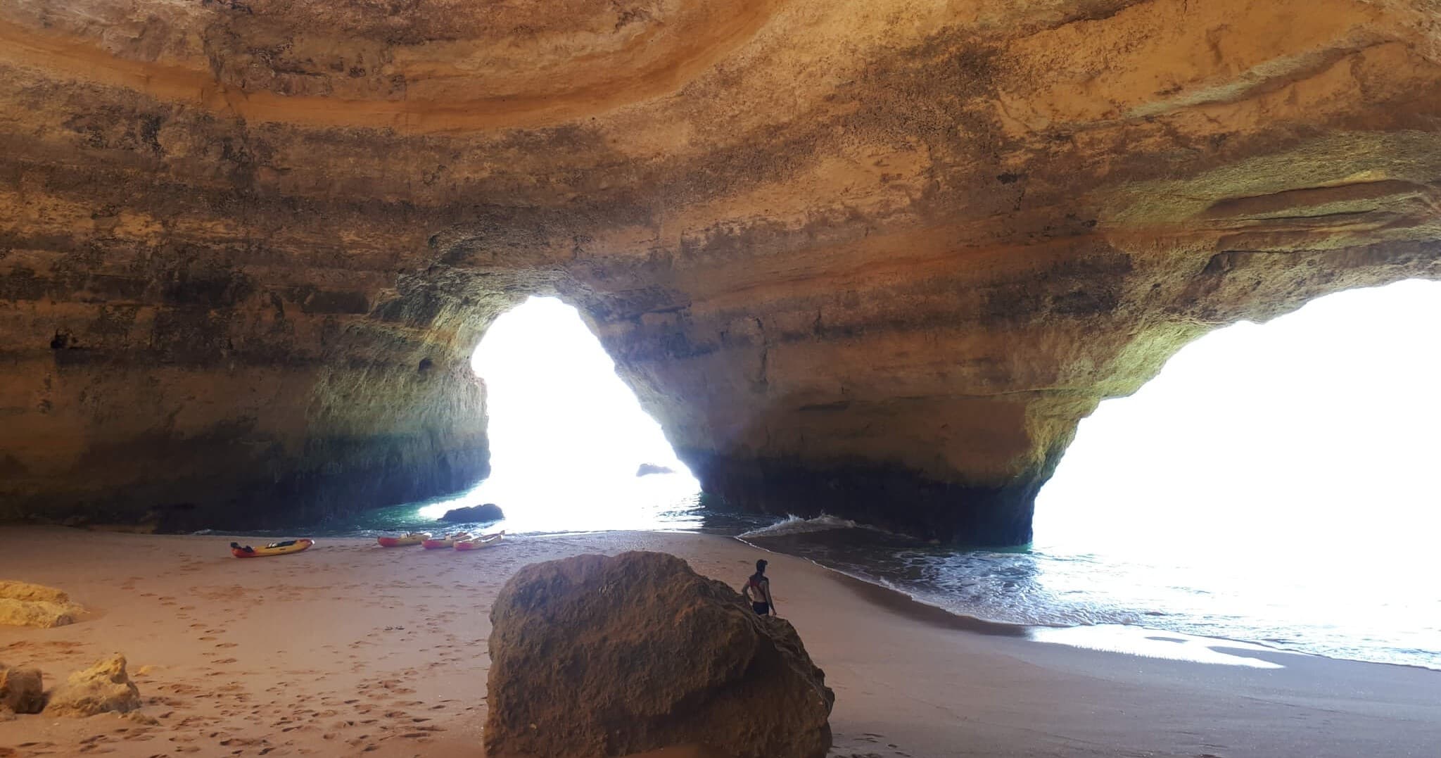 Interior view of Benagil sea cave with beach and rock arches