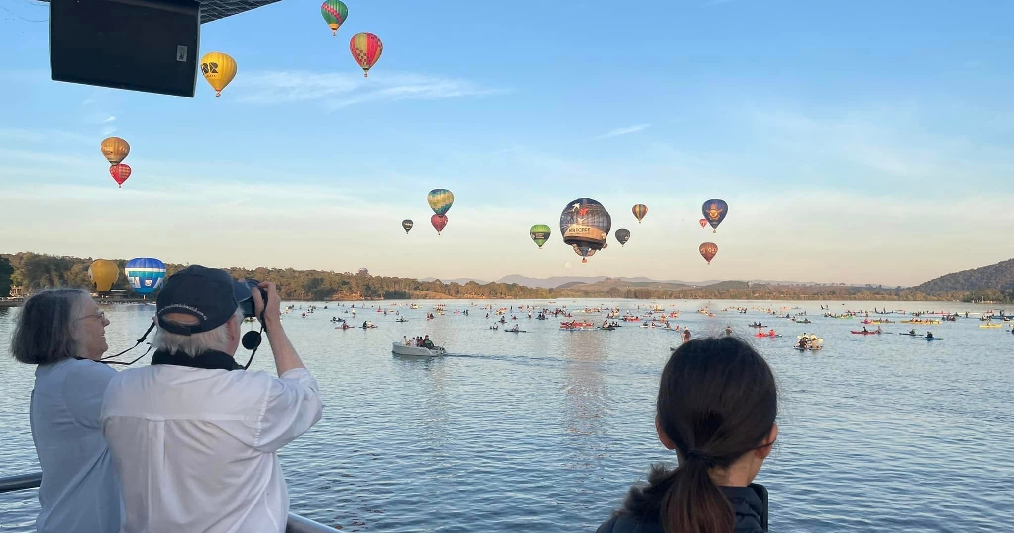 Spectators watching hot air balloons over Lake Burley Griffin