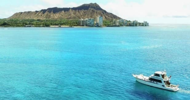 Turquoise bay with boat near volcanic island, scenic sea tour