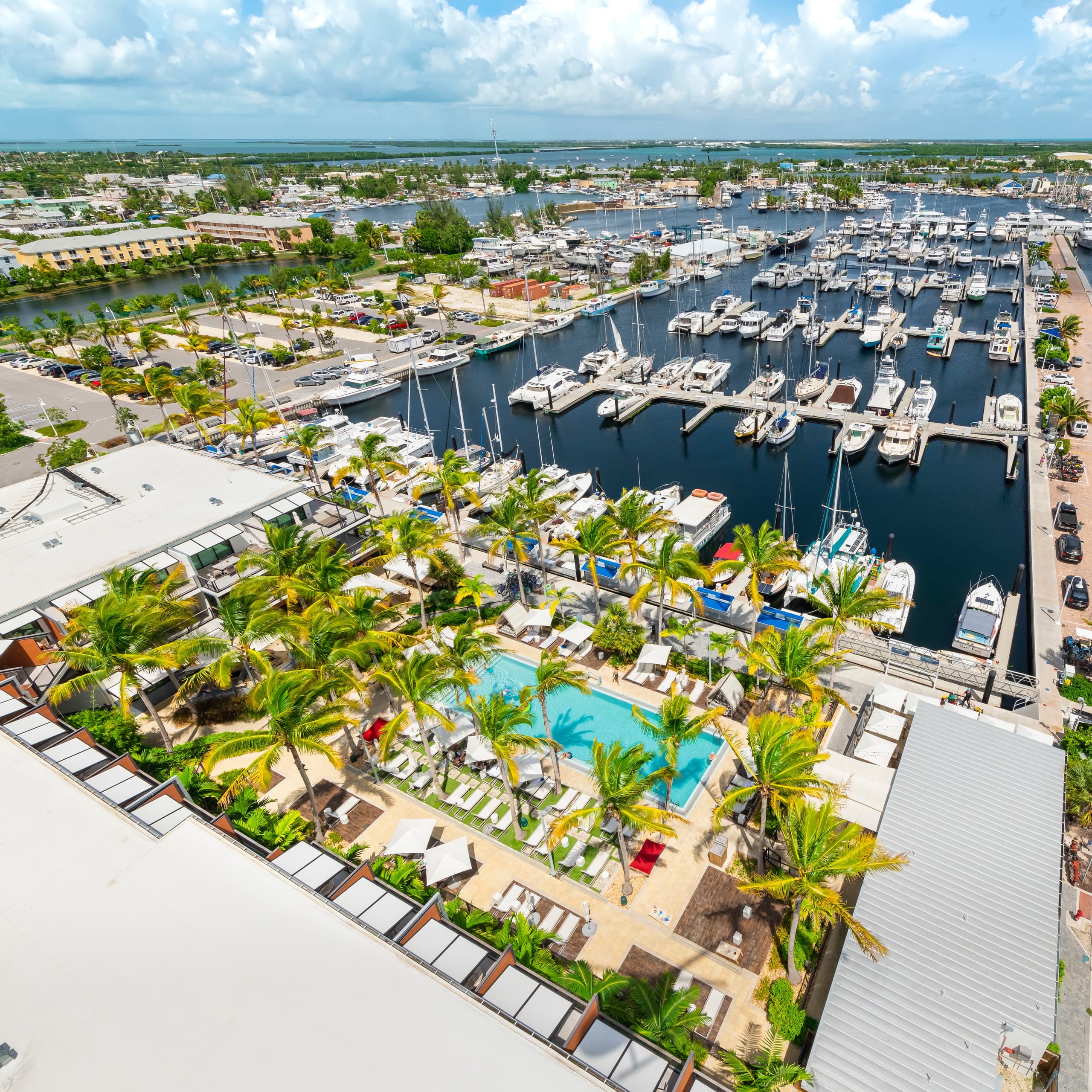 Aerial resort marina with boats, pools and palm-lined docks