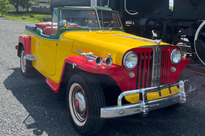 Vintage convertible parked at historic outdoor attraction, tour