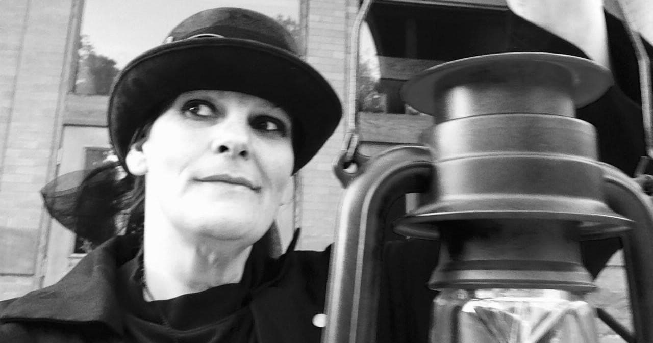 Guide with lantern leading historic ghost walk on streets