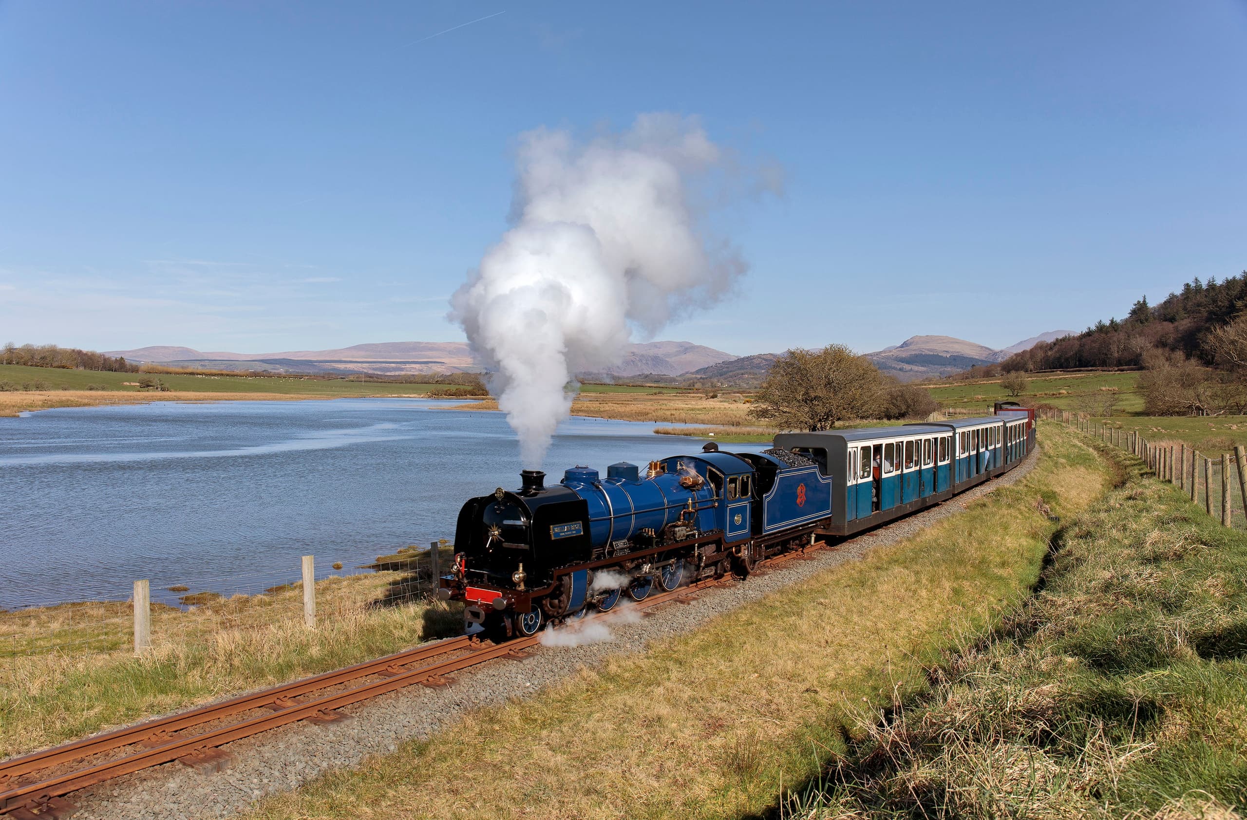 Steam train passing lakeside on Ravenglass-Eskdale line