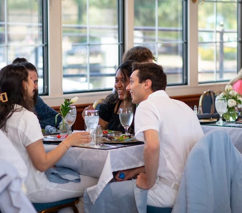 Friends enjoying waterfront dining aboard scenic river cruise