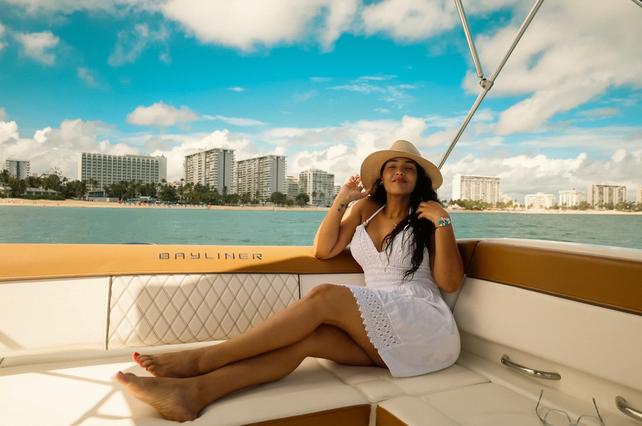 Woman relaxing on luxury boat with city skyline in background