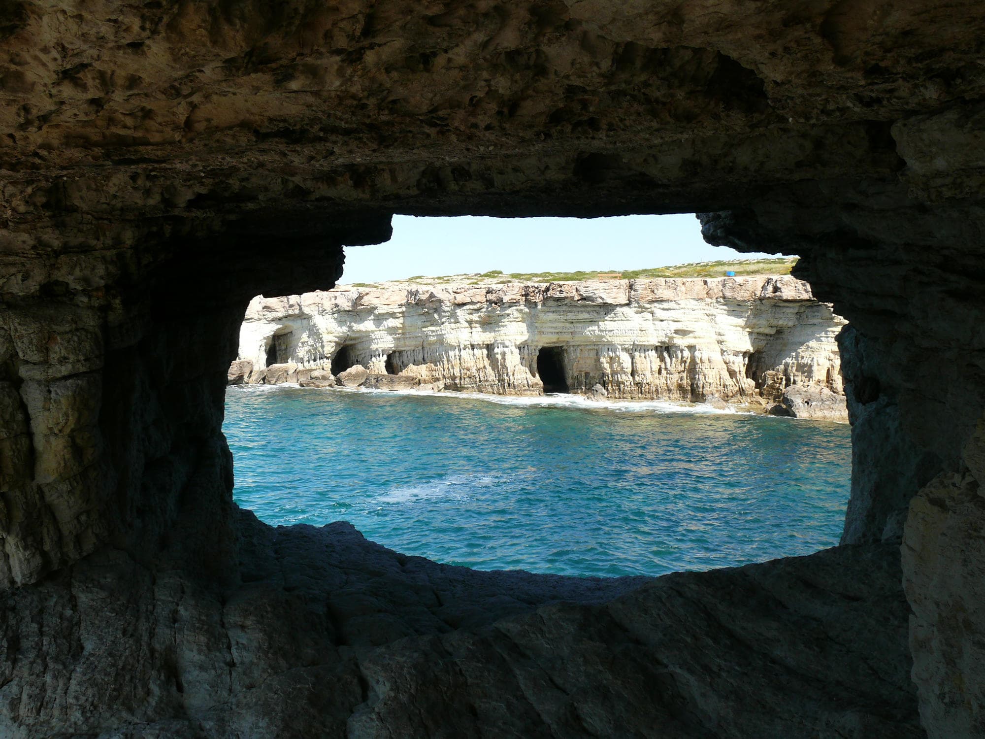 Sea cave window framing turquoise Mediterranean waters in Cyprus
