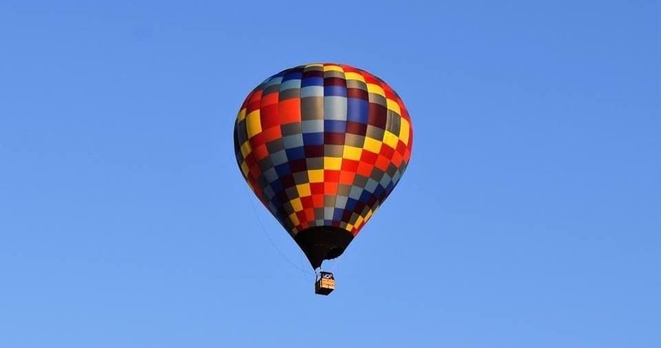 Colorful hot air balloon drifting against clear blue sky