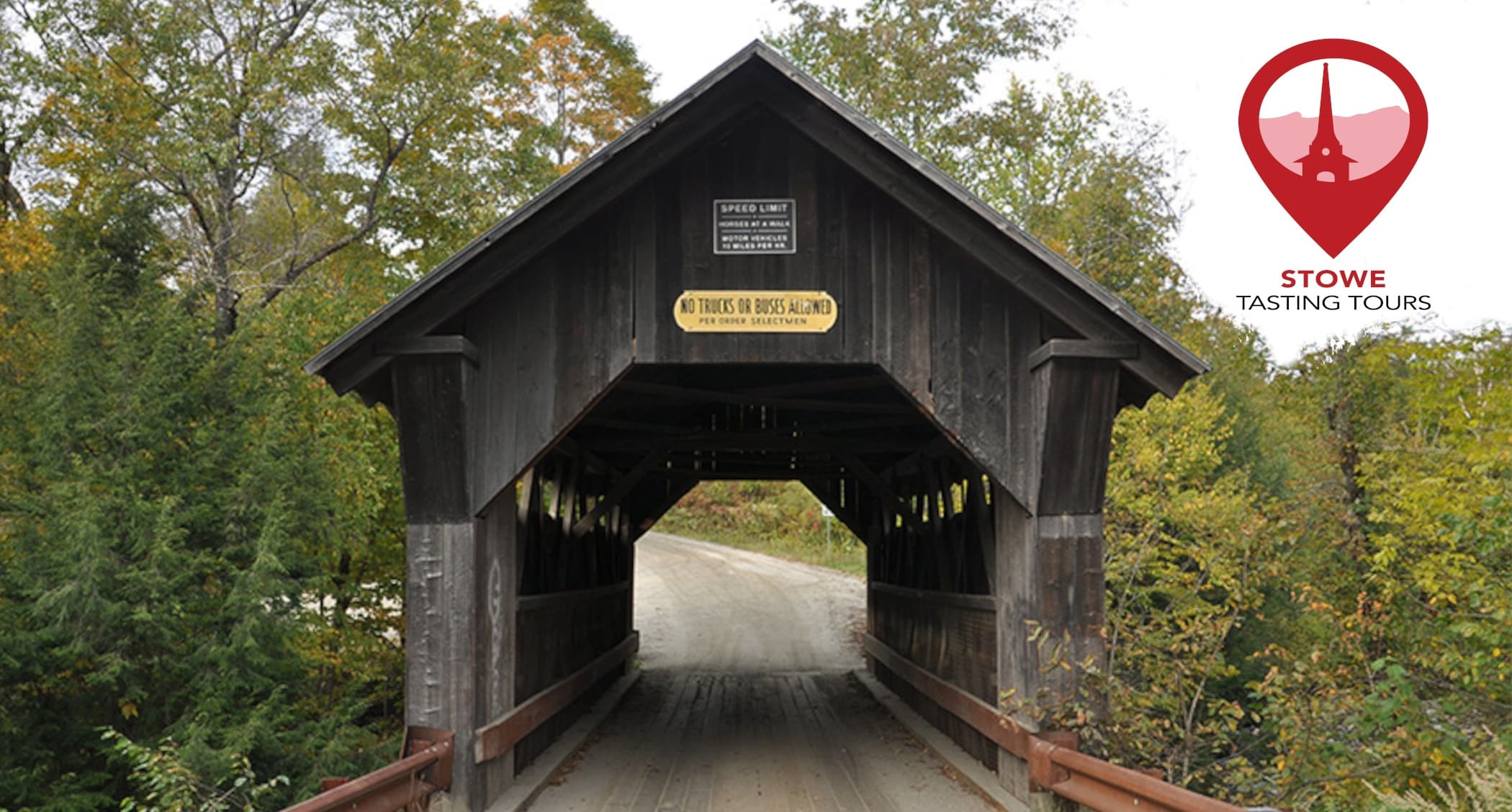 Historic covered bridge over Vermont forest road, scenic drive