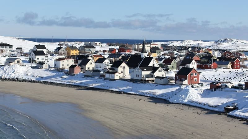 Snowy coastal village and beach on Arctic shoreline