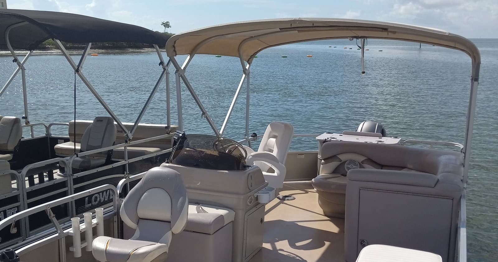 Pontoon boat seating and helm with coastal inlet views