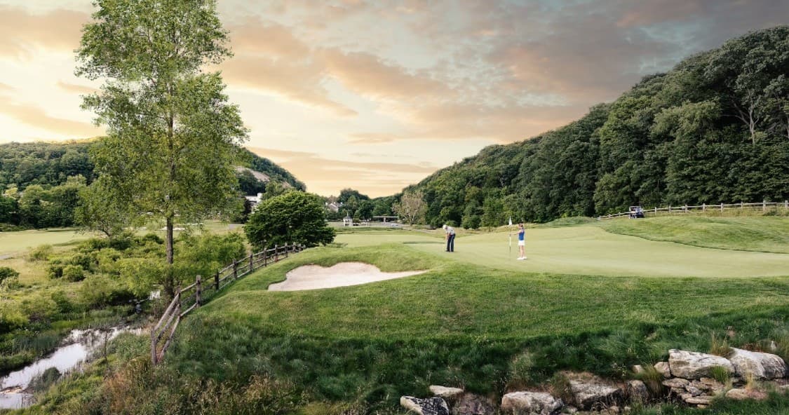 Golfers playing on rolling fairways at scenic resort course