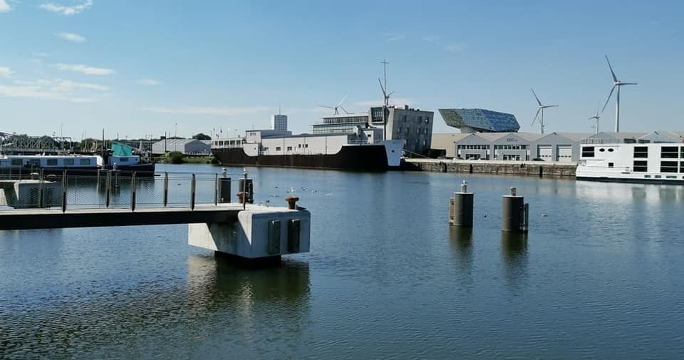 Scenic Antwerp marina with docks and wind turbines at harbor