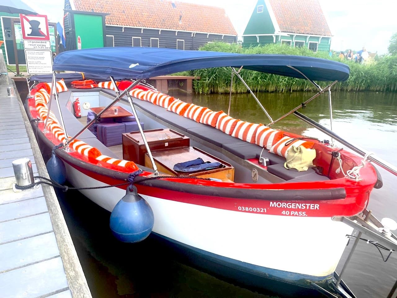 Mooring view of colorful Dutch tour boat at village quay under blue sky