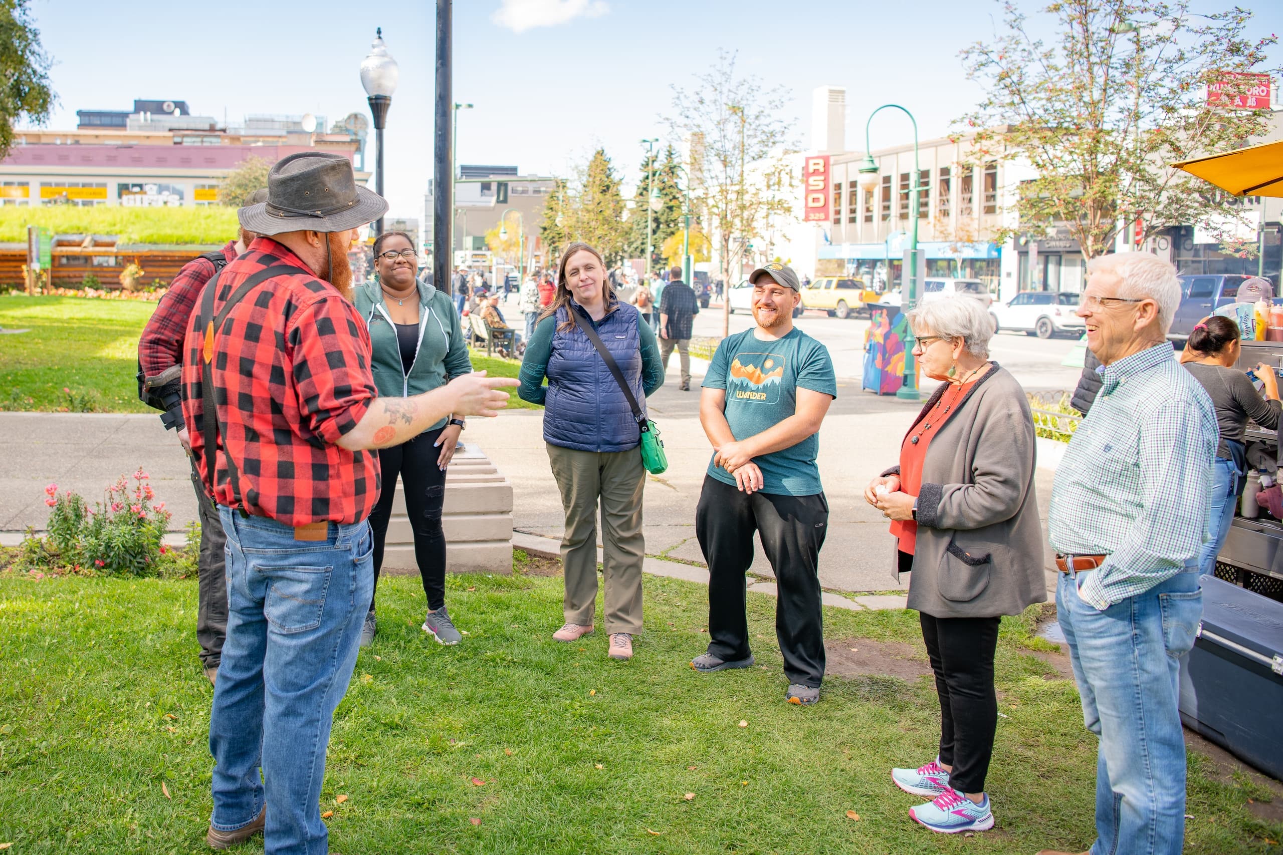 Guided walking tour group standing in downtown park setting