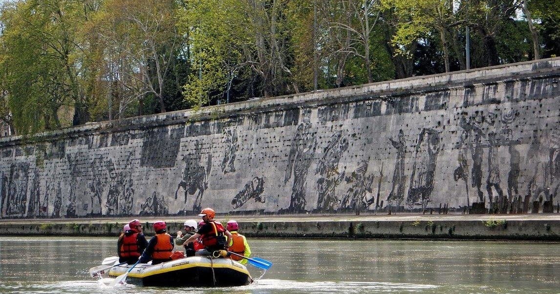 Raft floating past historic riverside wall on the Tiber in Rome