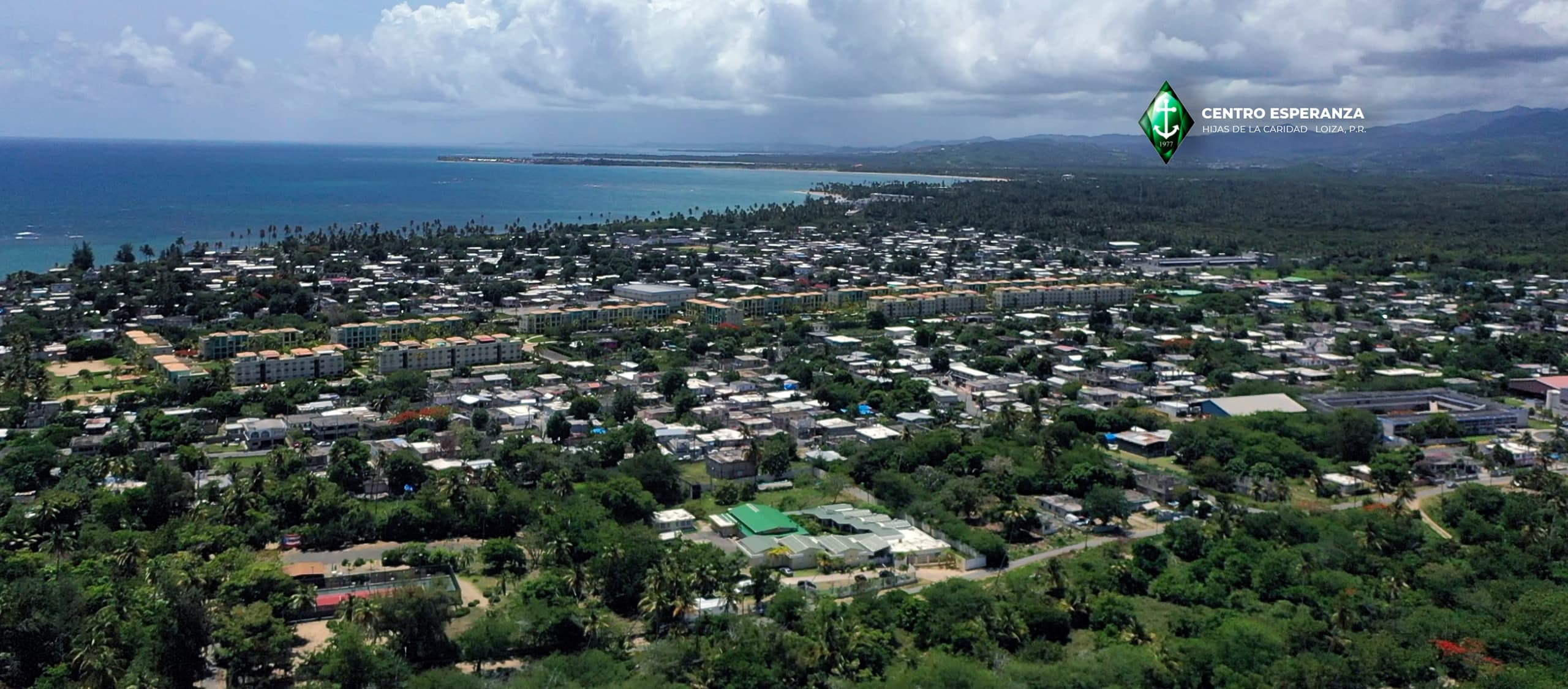 Scenic aerial view of coastal town and lush hills
