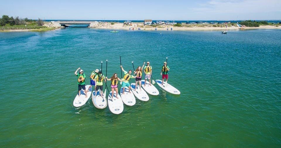 Aerial stand-up paddleboard group in calm coastal bay