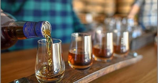 Distillery whiskey tasting flight poured at indoor bar