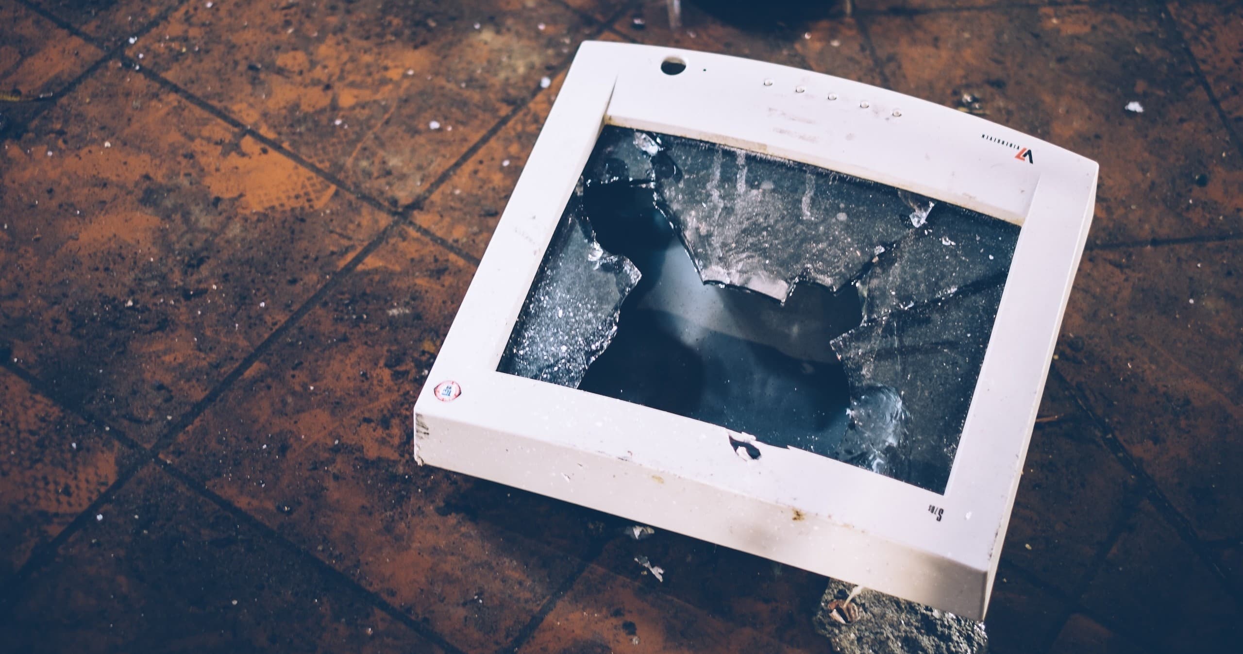 Broken computer monitor frame on floor in indoor smash experience