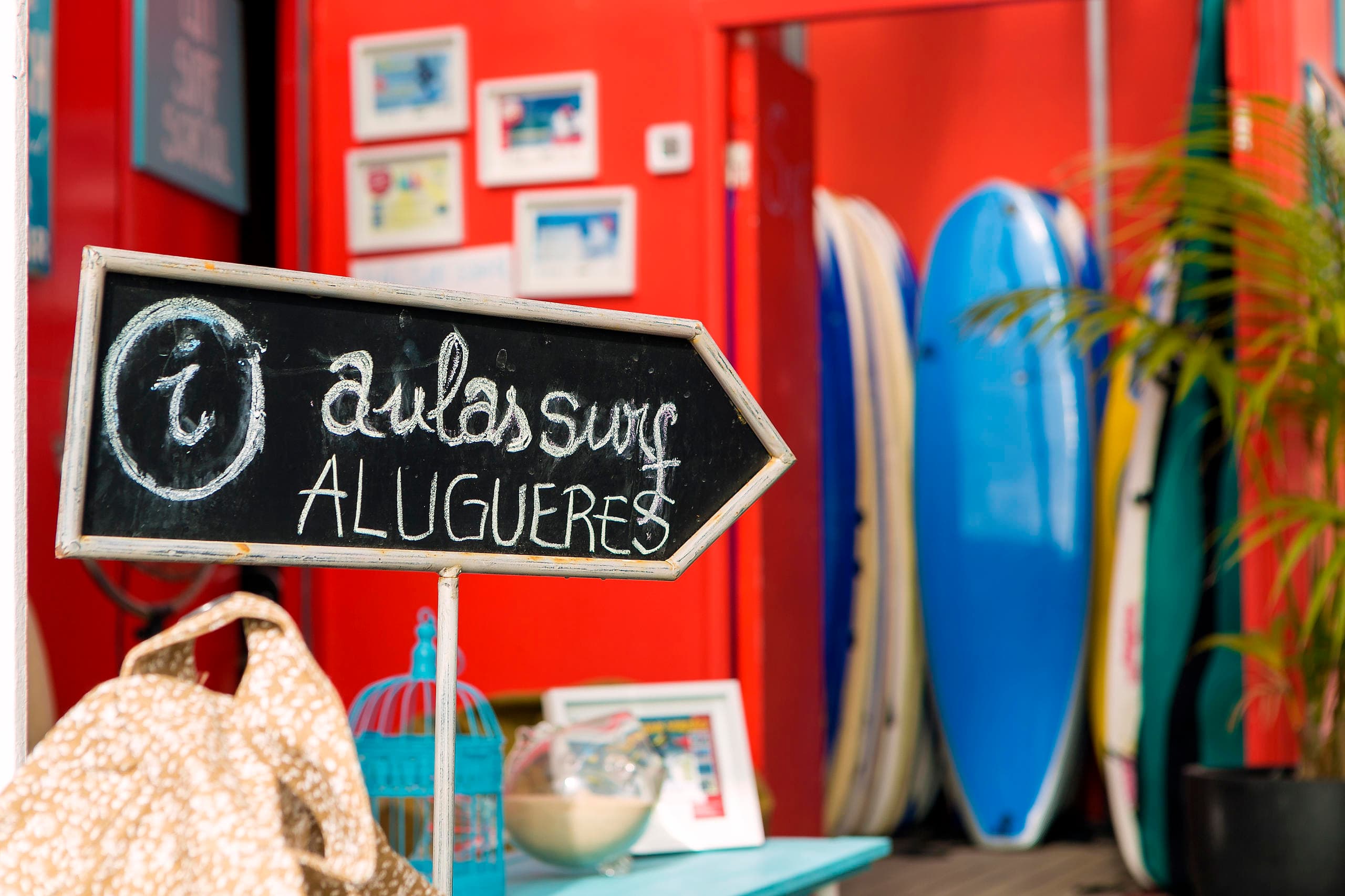 Surf school rental shop with boards and chalkboard sign, beachside