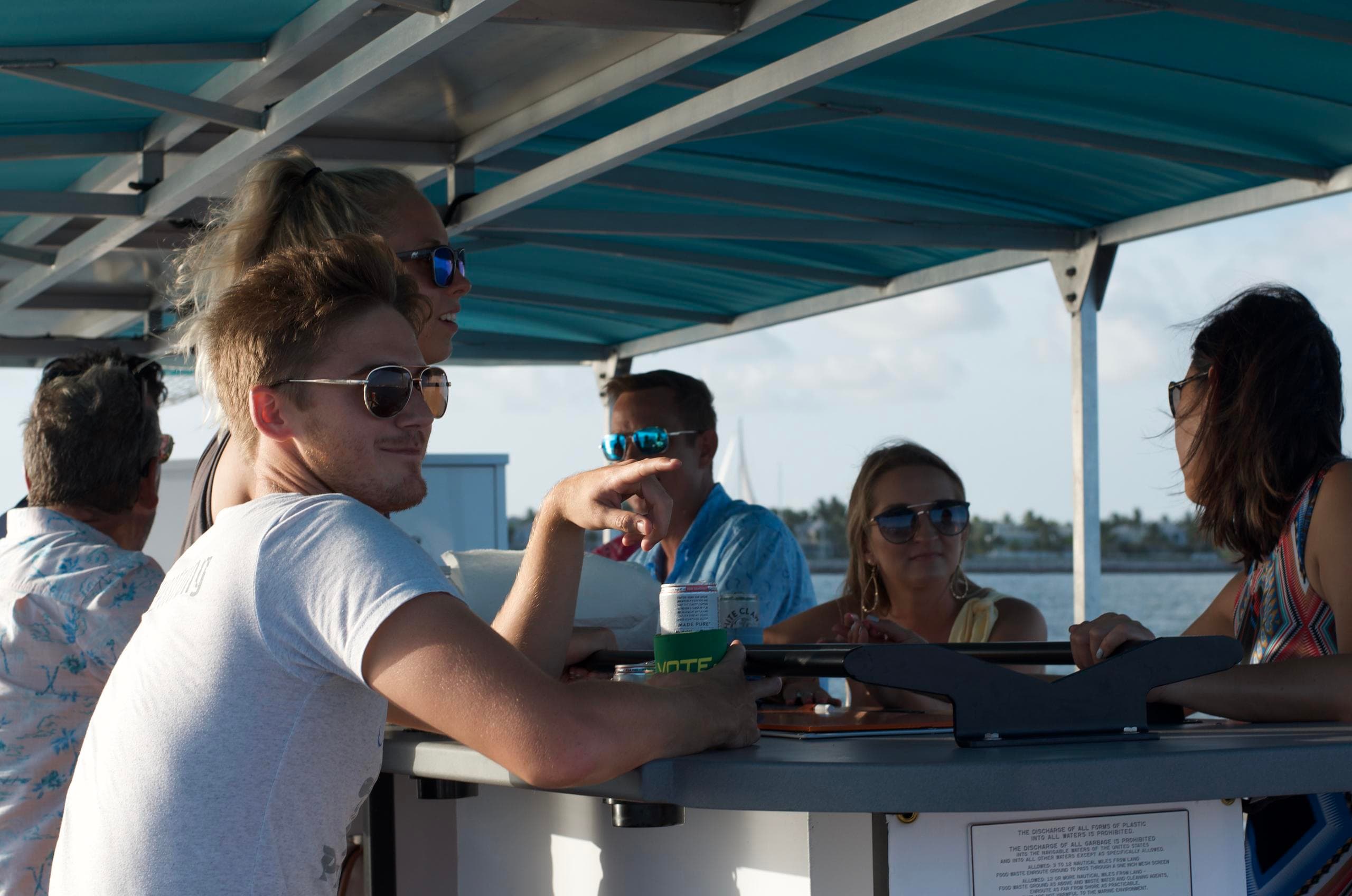 Group enjoying party boat ride under canopy in coastal waters