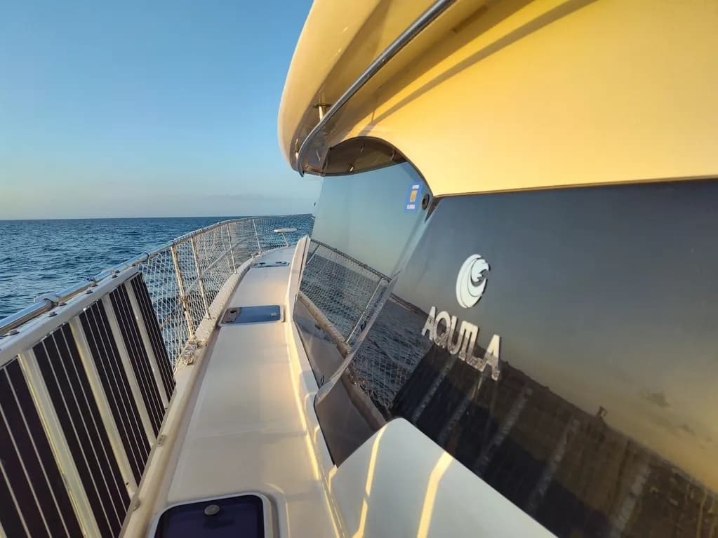 Walkway aboard motor yacht with ocean view and polished hull
