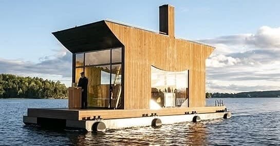 Floating wooden cabin sauna on a calm lake, scenic retreat