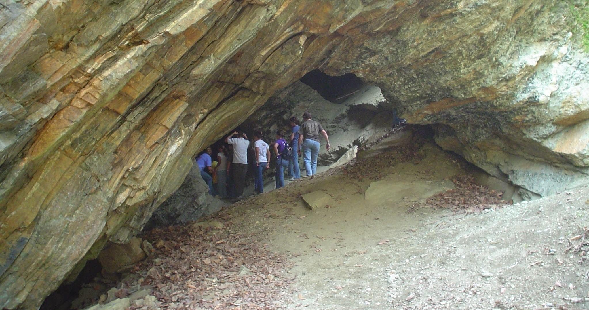 Guided cave exploration inside sandstone cave with hikers