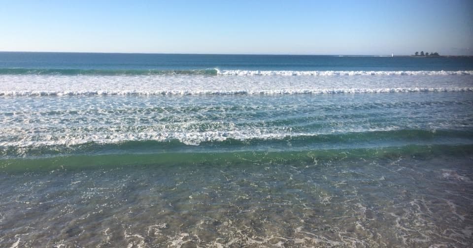 Calm ocean waves rolling onto sandy Port Fairy beach shoreline