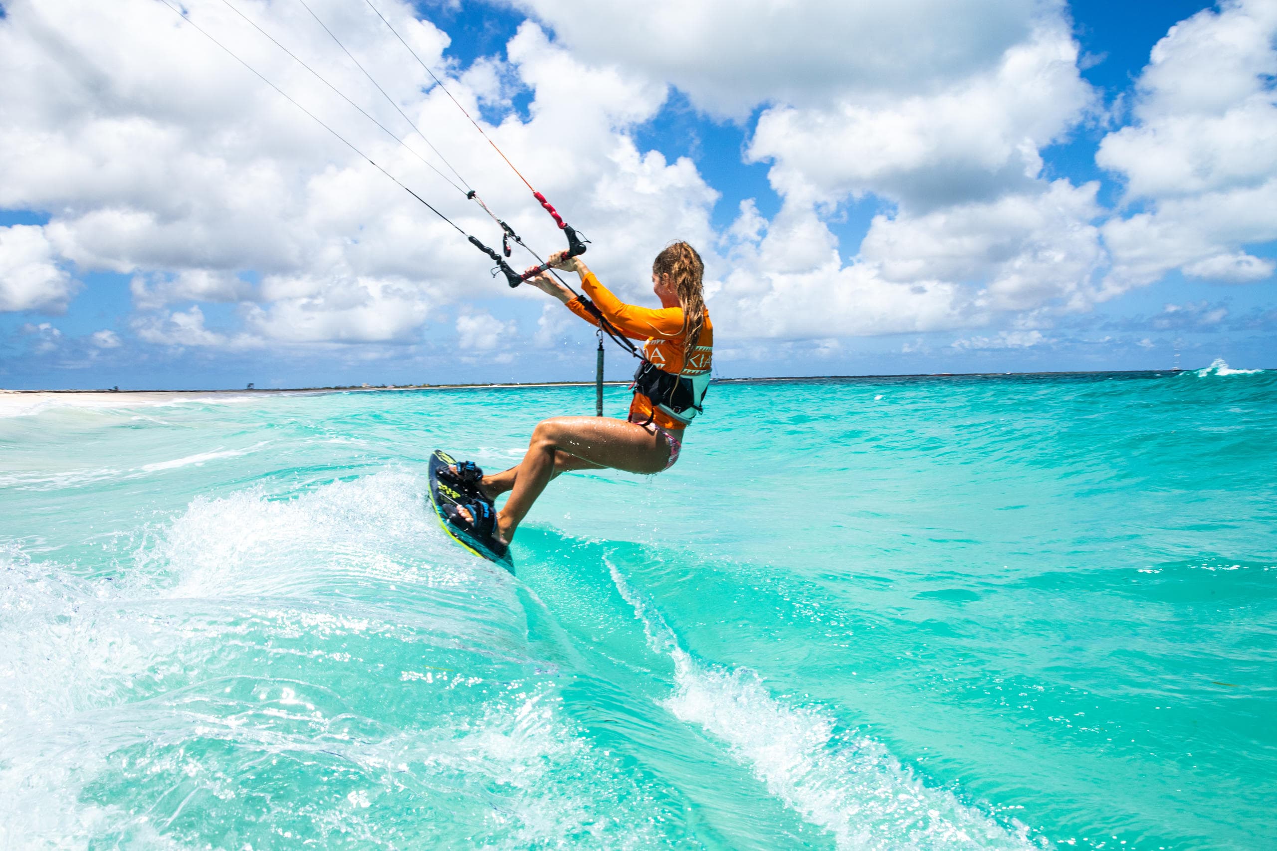Colorful catamaran sailing with passengers on bright coastal water