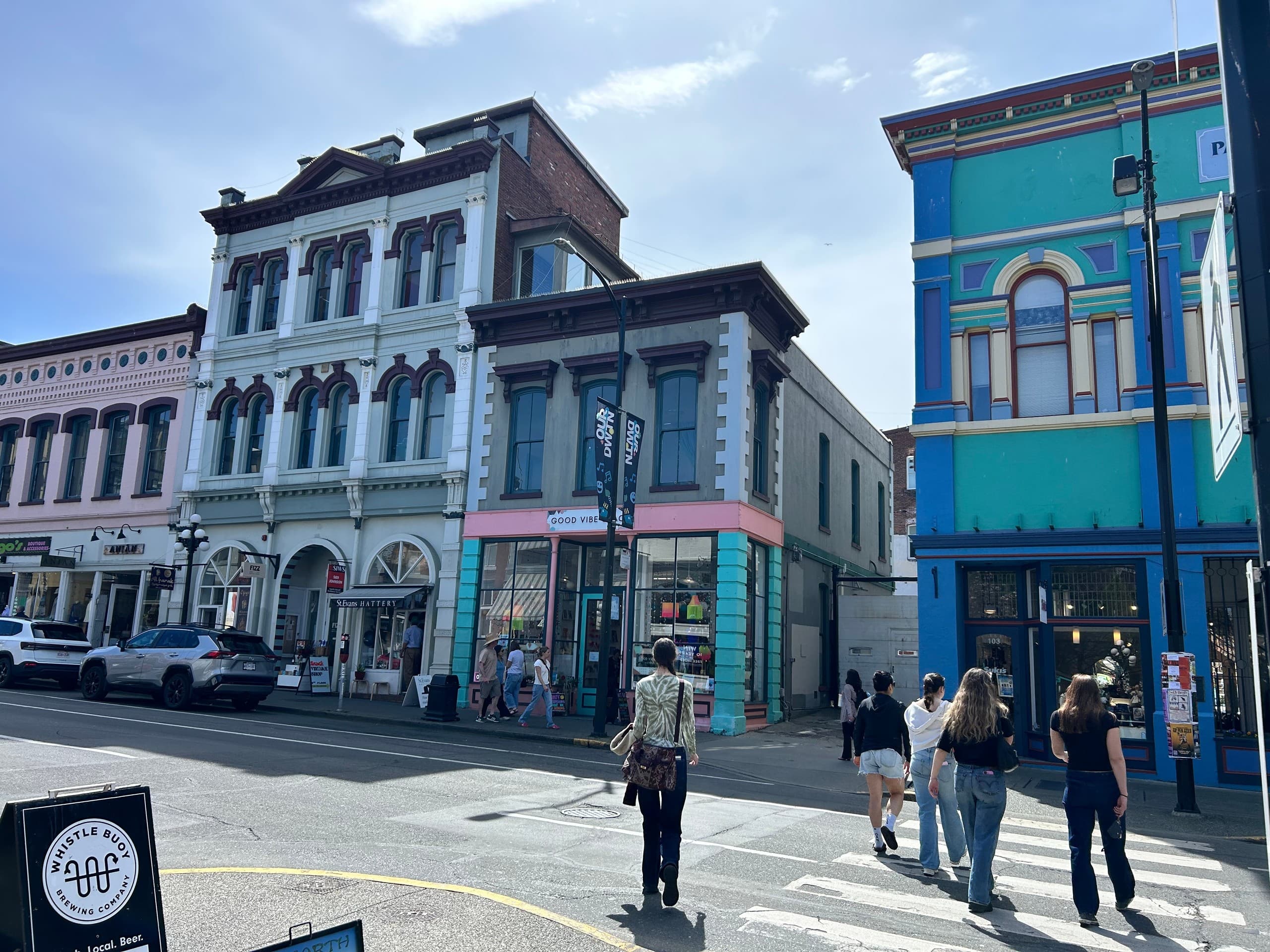 City street with historic storefronts and pedestrians walking