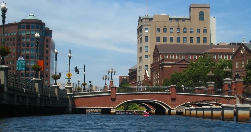 Kayakers navigating under downtown Providence river bridge