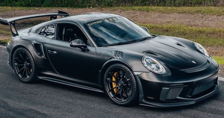 Black Porsche GT3 RS parked on scenic roadway, high-performance