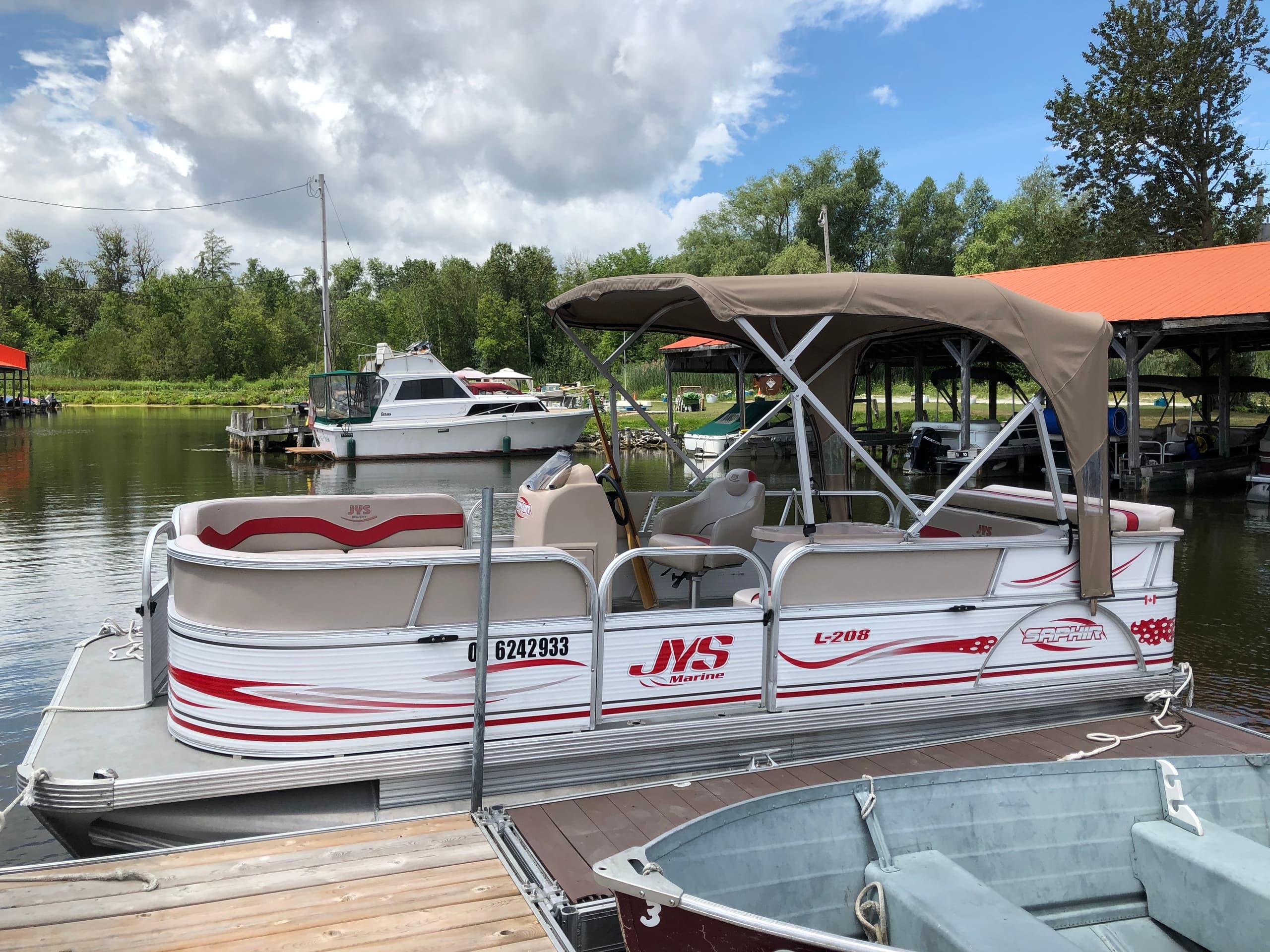 Pontoon boat moored at Scugog Island Marina under sky