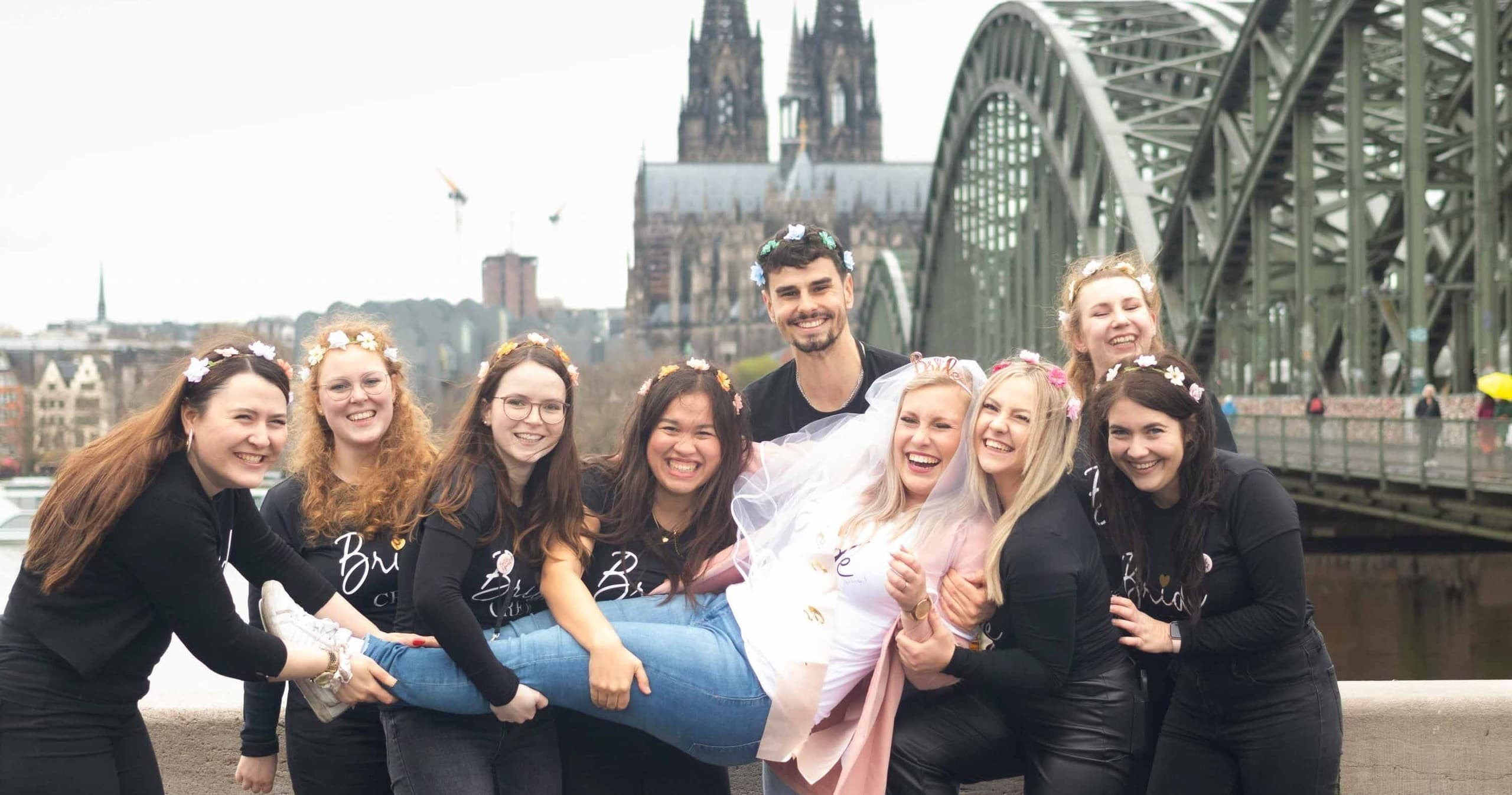 Walking tour group posing with Cologne Cathedral and Rhine