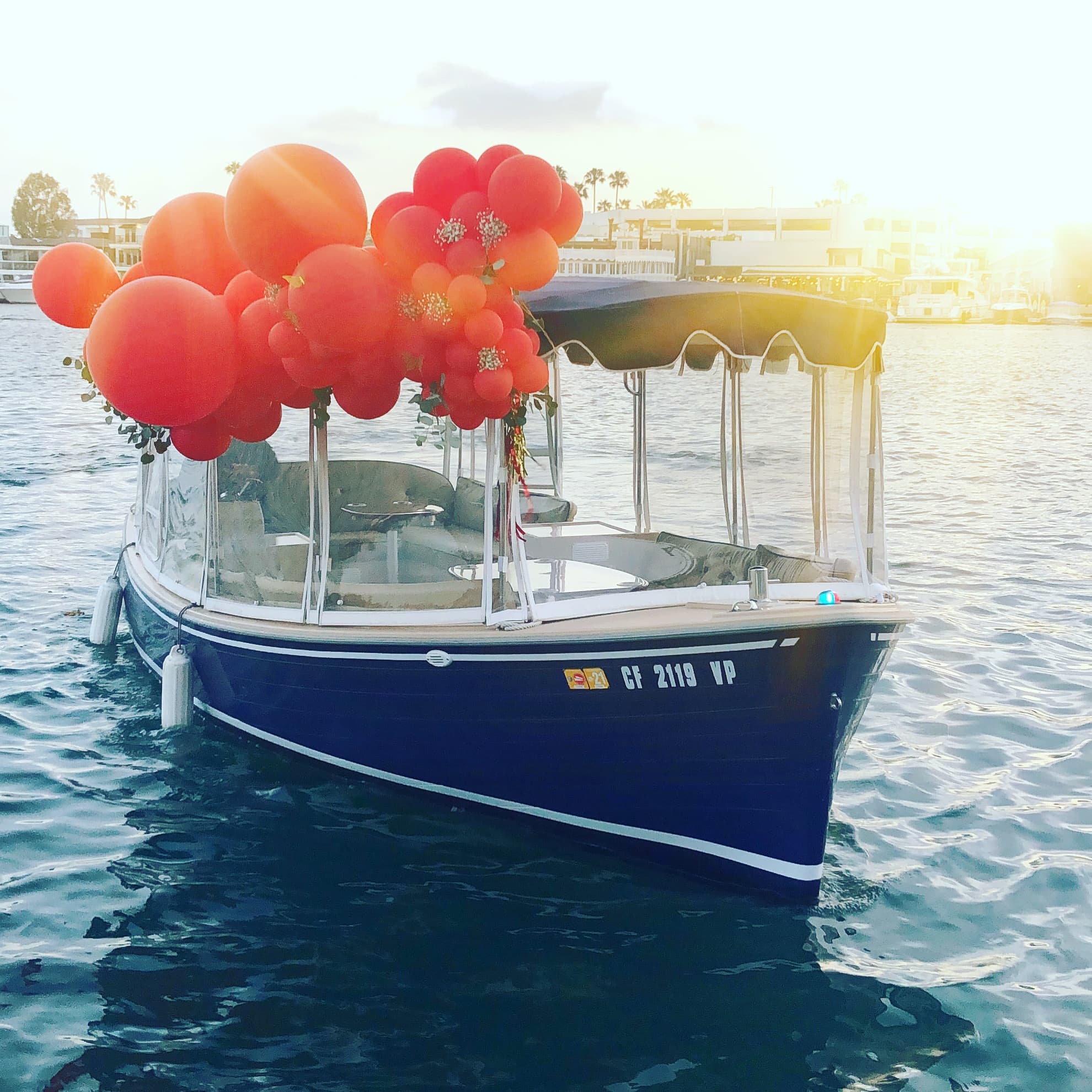 Decorated motorboat with red balloons on sunny marina waters