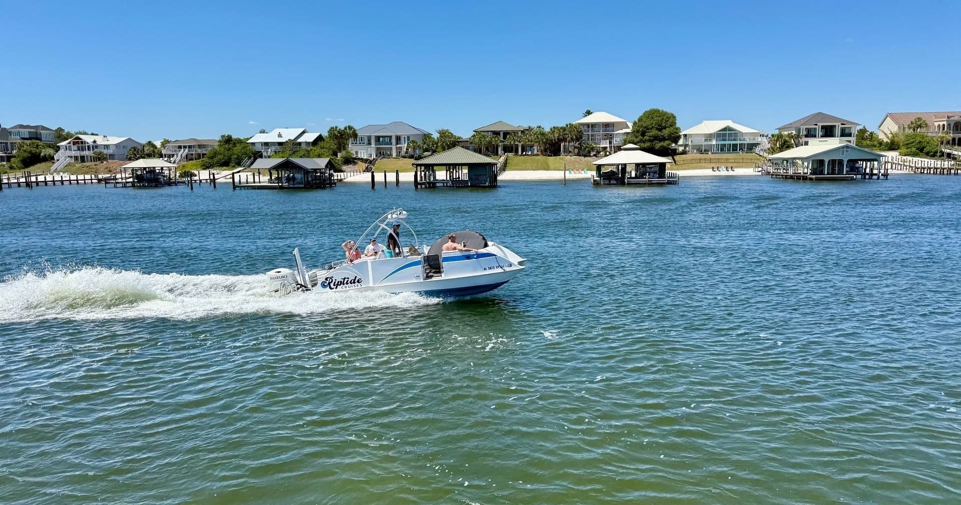 Speedboat cruising through coastal inlet with waterfront homes