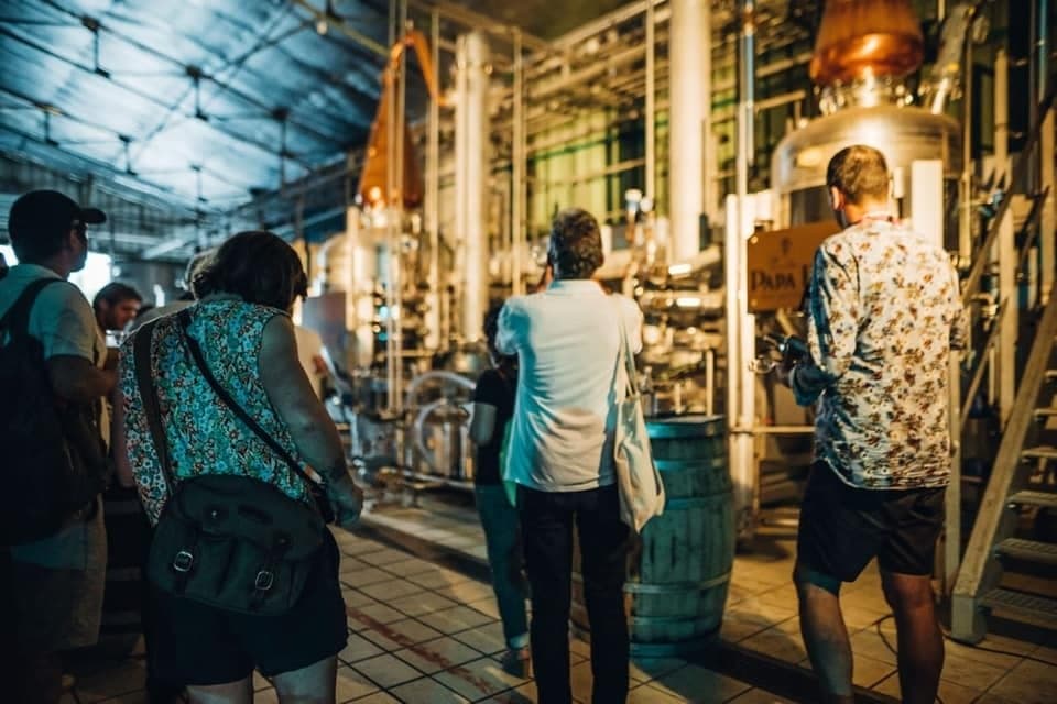 Visitors touring industrial rum distillery production area in Guadeloupe