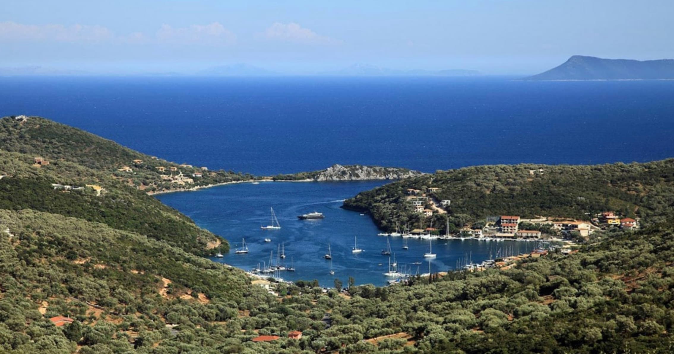 Panoramic coastal bay and harbor view with anchored sailboats