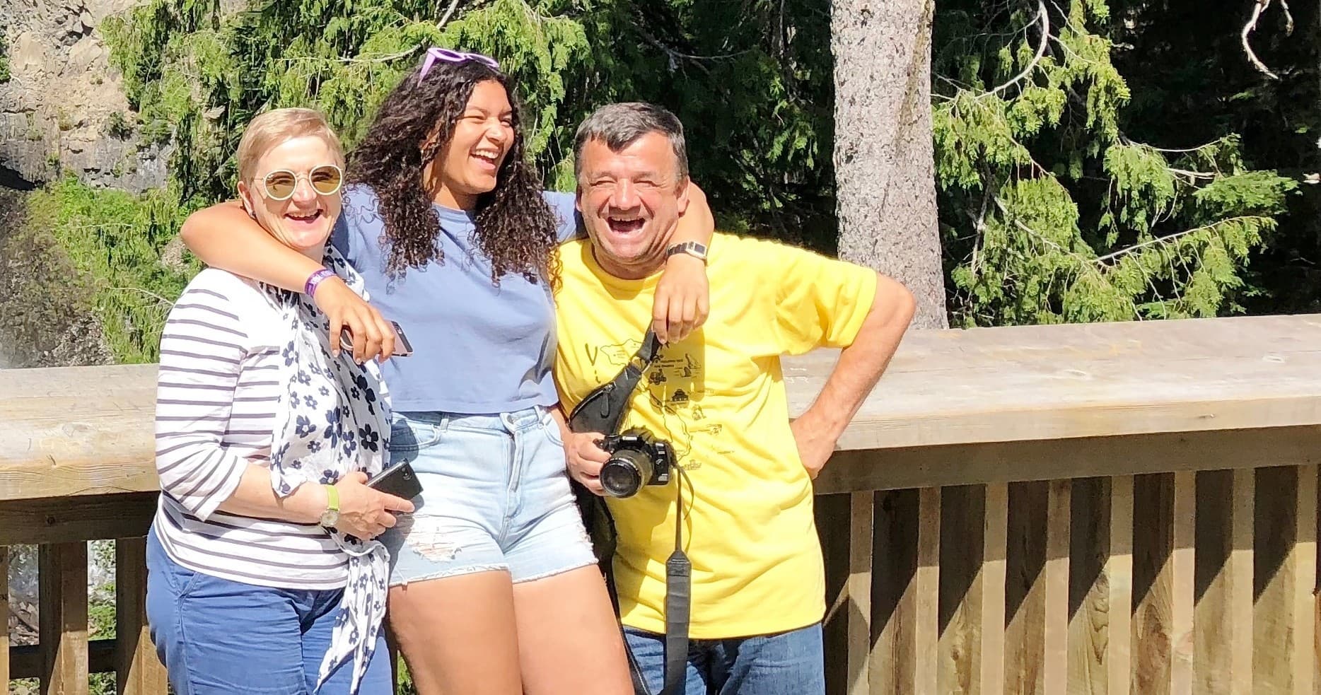 Family smiling on wooden viewpoint deck in Whistler forest setting